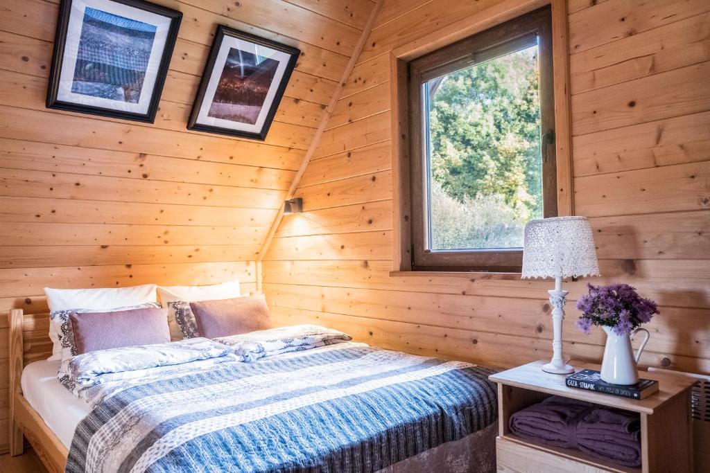 1 dormitorio con 1 cama en una cabaña de madera en Szalejówka Domki, en Kłodzko