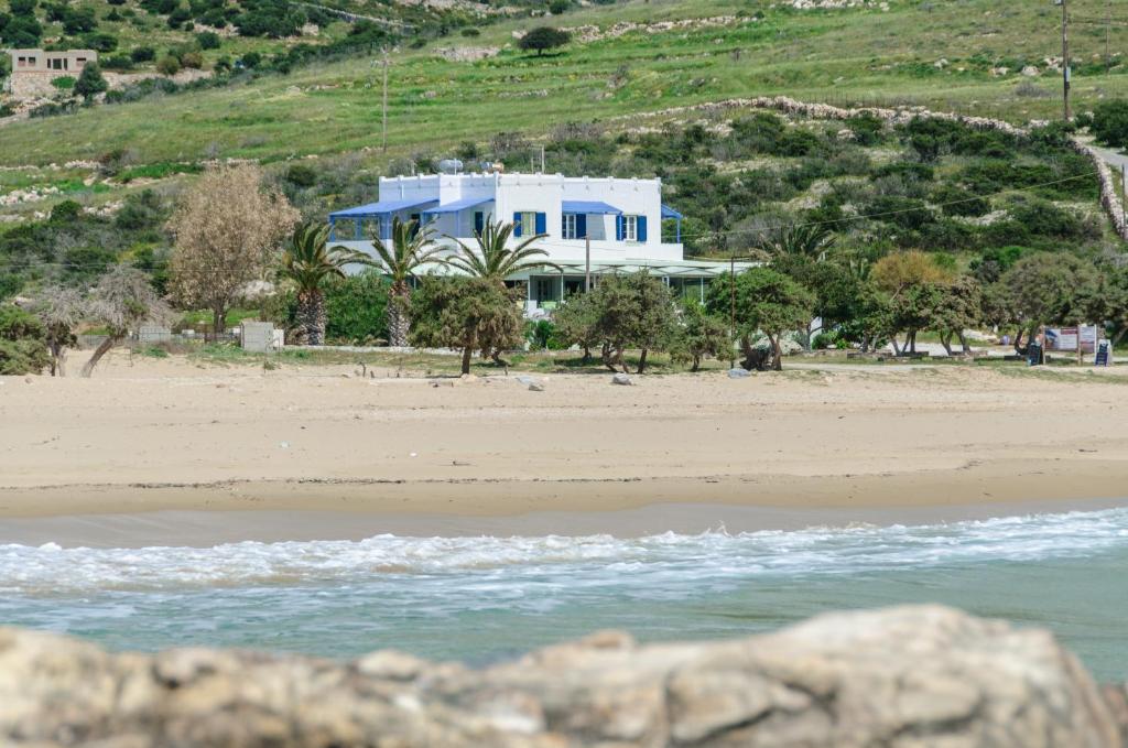 ein blaues Haus am Strand mit dem Meer in der Unterkunft Psili Ammos Studios in Aliko Beach