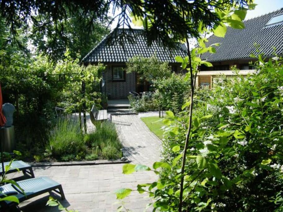 um jardim com um caminho de pedra que leva a uma casa em Studio bed & Strand em Scharendijke