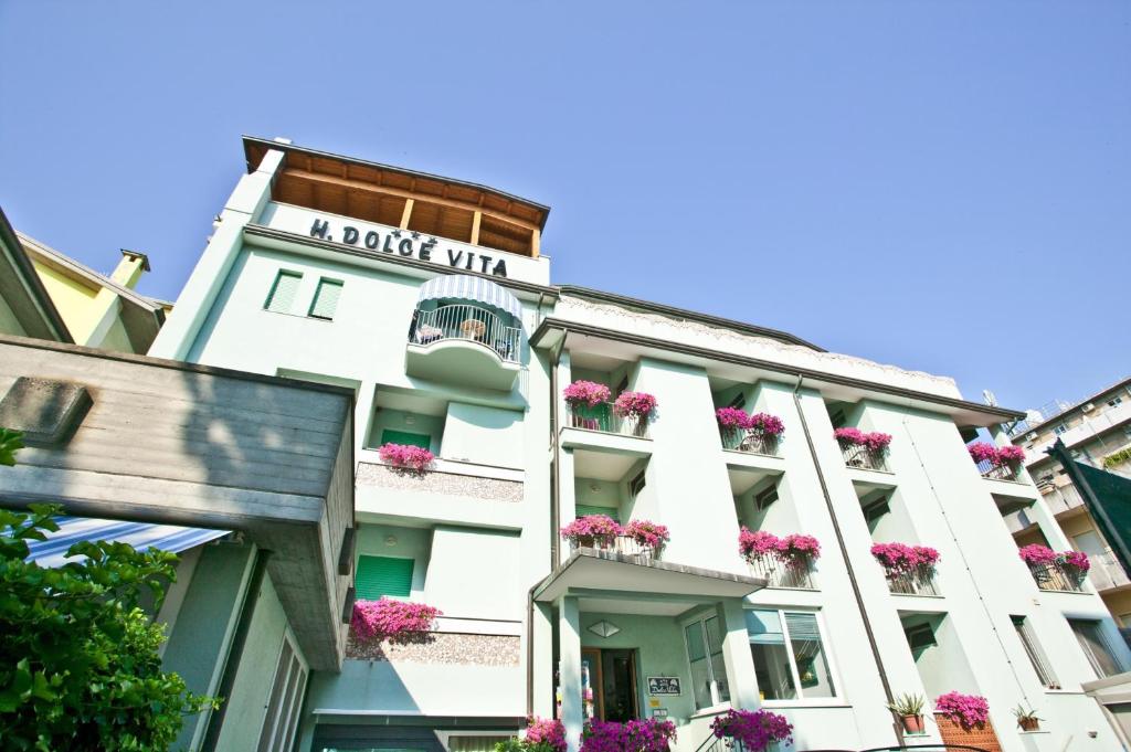 a white building with flowers on the balconies at Hotel Dolcevita in Cesenatico