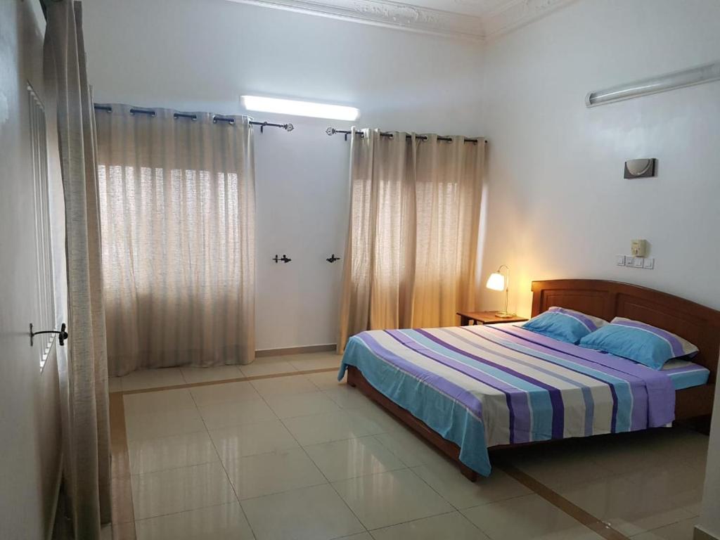 een slaapkamer met een bed in een witte kamer bij RESIDENCE OLUSHOLA in Cotonou