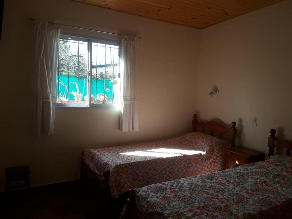 een slaapkamer met 2 bedden en een raam bij La Primavera in San Salvador de Jujuy