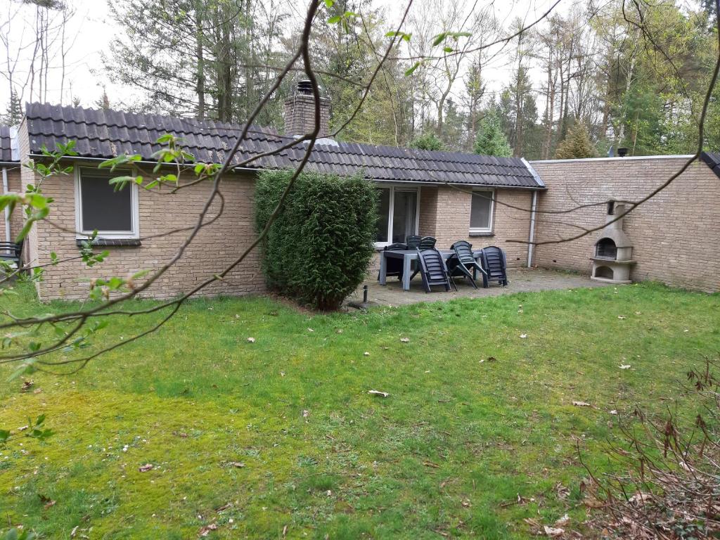 a house with chairs and a table in the yard at Vakantiehuis Lochem in Lochem