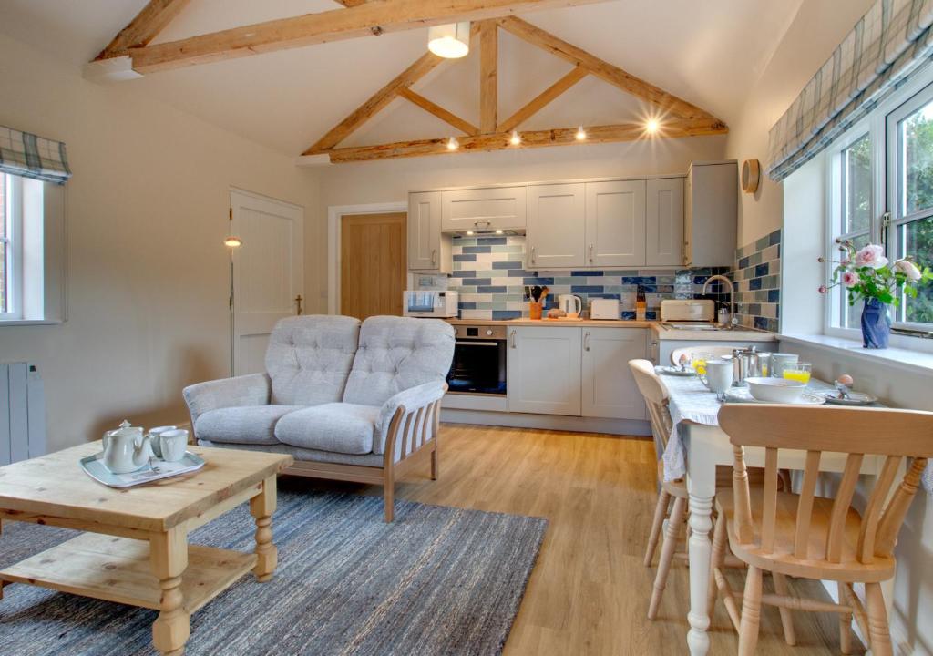 a kitchen and living room with a table and chairs at The Old School House in Reepham