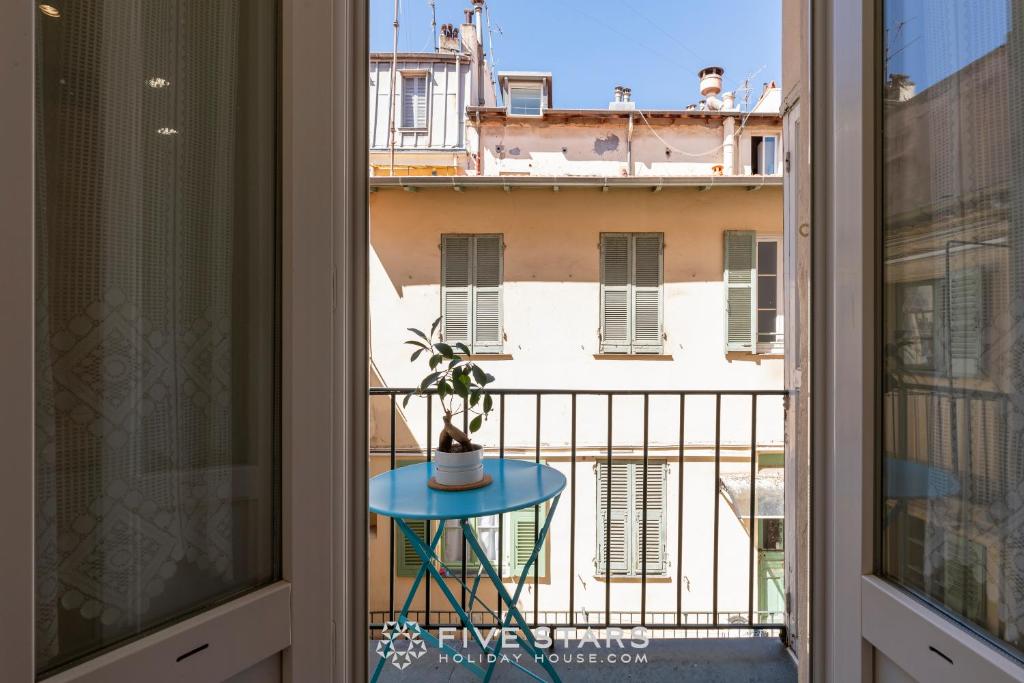 une table avec une plante assise au-dessus d'un balcon dans l'établissement Suite La bohème Five stars Holiday house, à Nice
