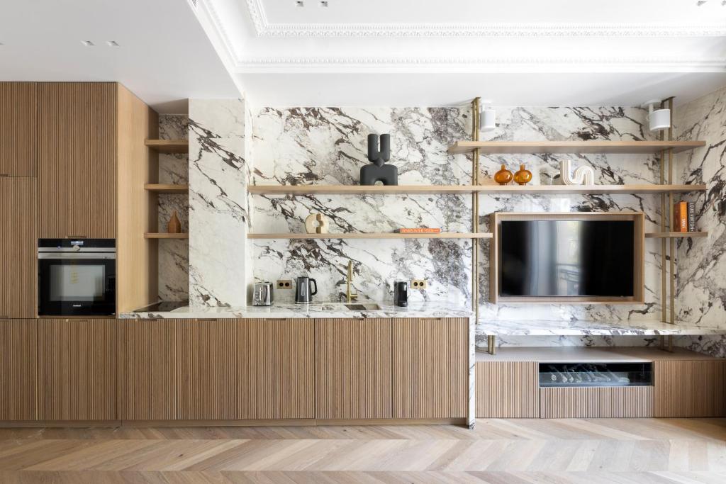 a living room with a tv and a marble wall at HIGHSTAY - Luxury Serviced Apartments - Le Marais in Paris