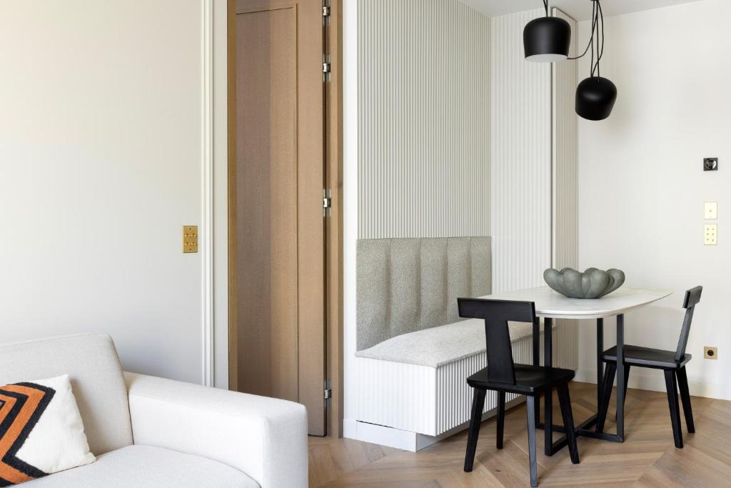 a living room with a table and a chair at HIGHSTAY - Luxury Serviced Apartments - Le Marais in Paris