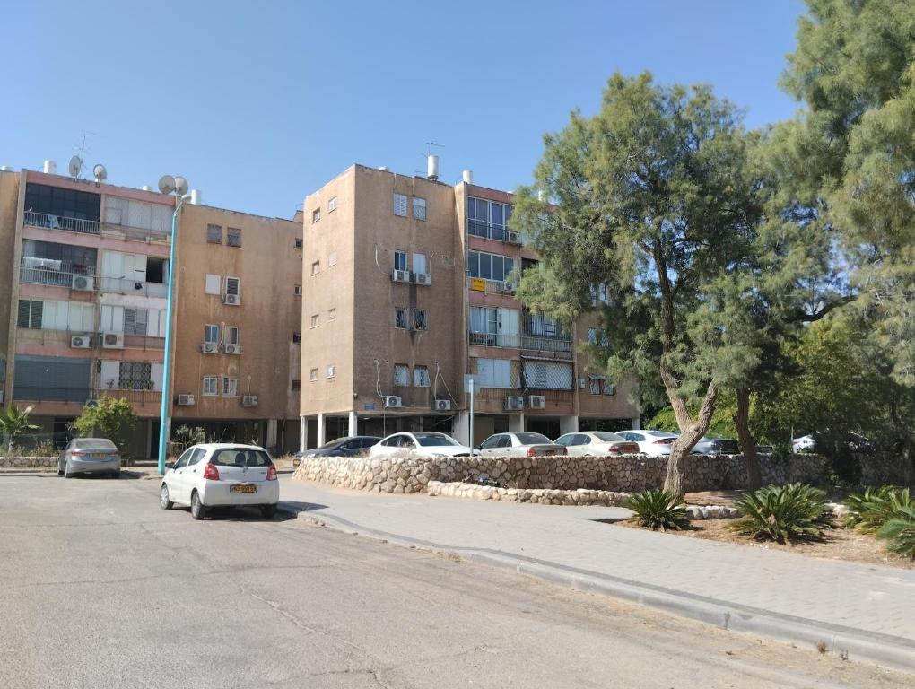 un estacionamiento con autos estacionados frente a un edificio en פטל en Beer Sheva