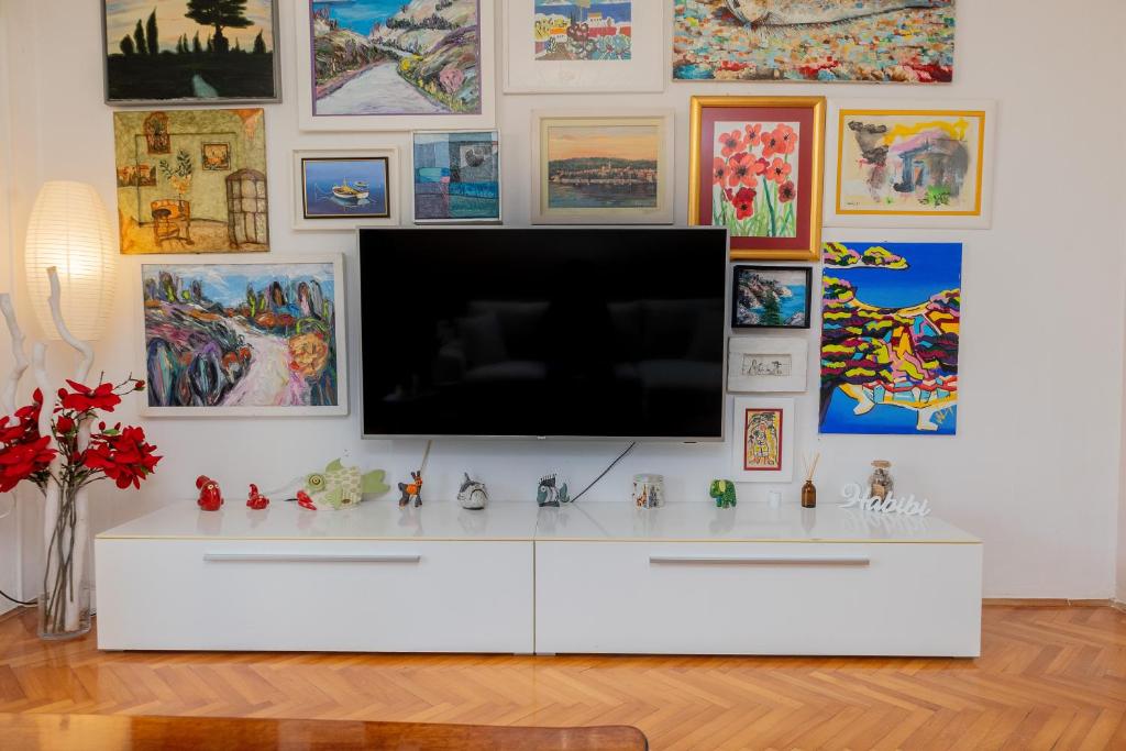 a living room with a television on a white cabinet at Art & Gallery Vacation Home in Korčula
