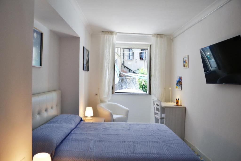 una camera con un letto blu e una finestra di Casa Bianca Amalfi ad Amalfi