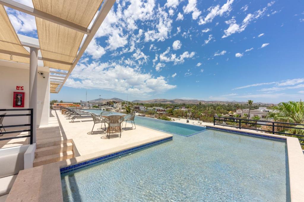 a swimming pool with a table and chairs on a balcony at Lumina at Cardinal San José del Cabo in San José del Cabo