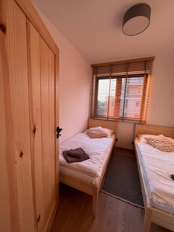 een slaapkamer met 2 bedden en een raam bij Apartament w Dolinie Sanu 2 in Lesko