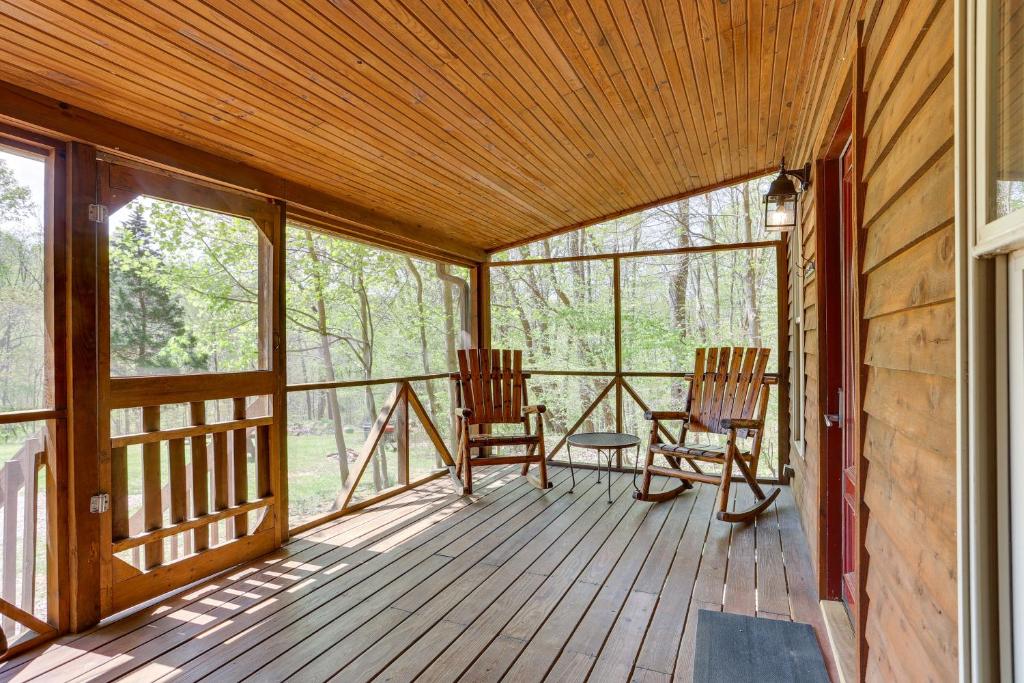 eine abgeschirmte Veranda mit 2 Stühlen und einem Tisch in der Unterkunft Dreamy Indiana Cabin Rental with Shared Amenities! in Taswell