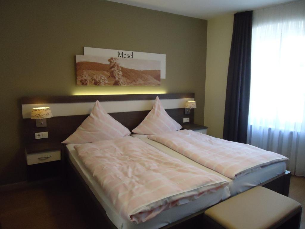Un dormitorio con una cama con almohadas. en Gasthaus Huwer en Bernkastel-Kues