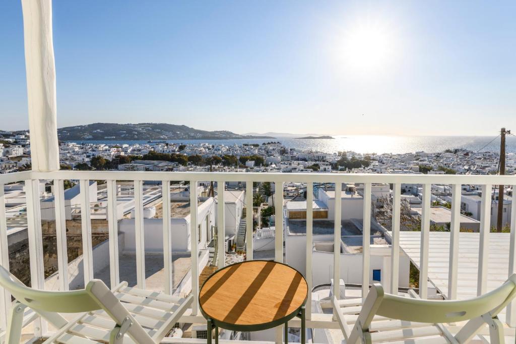 a balcony with chairs and a table and the ocean at Blueisla Sea View Suite A in Mikonos