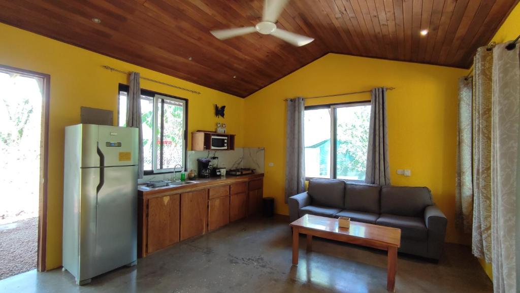 a kitchen with a refrigerator and a couch in a room at Casas Guanacaste Marbella in Marbella