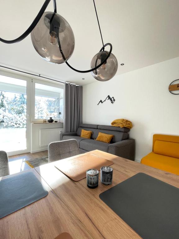 a living room with a table and a couch at Maisonnette am Bikepark Winterberg mit Terrasse Loggia Garage in Winterberg