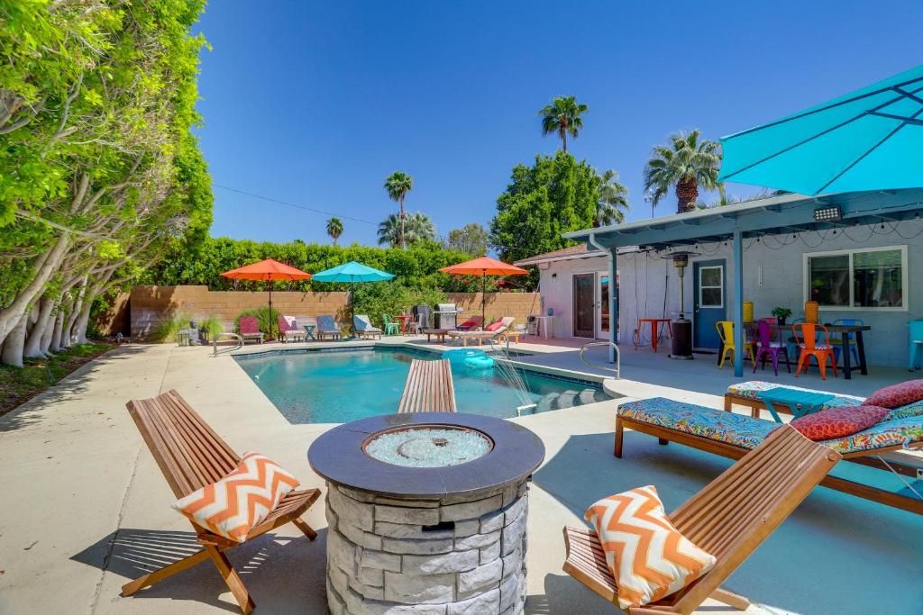 una piscina con 2 sillas y una mesa con chimenea en Palm Springs Getaway with Shared Outdoor Pool!, en Palm Springs