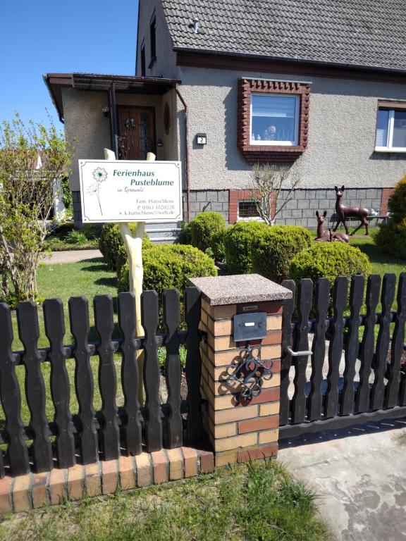 a fence with a sign in front of a house at Ferienhaus Pusteblume in Lübben