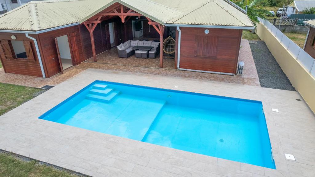 uma piscina em frente a uma casa com um pavilhão em Villa exotique em Le Moule