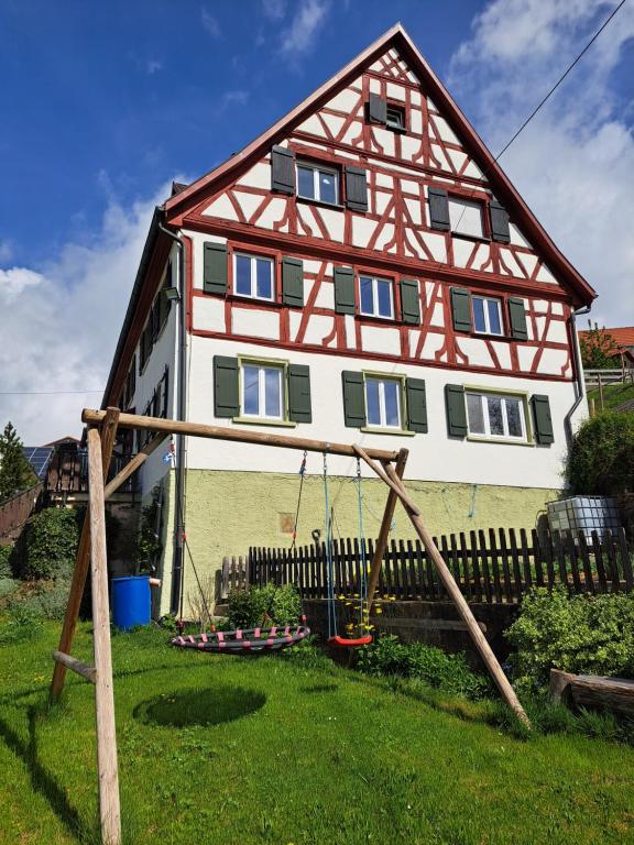 une maison avec une balançoire dans la cour dans l'établissement Ferienwohnung Butscher, à Riedlingen