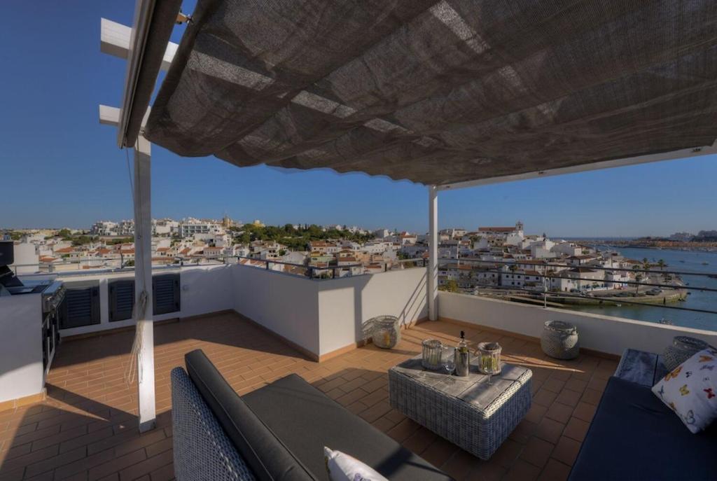 a balcony with a couch and a view of a city at Vila Vida in Ferragudo