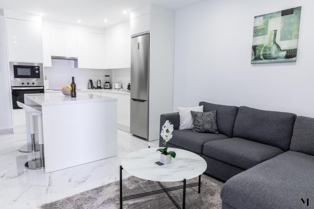 a living room with a couch and a table at Aqua Vista Playa San Juan in Playa de San Juan