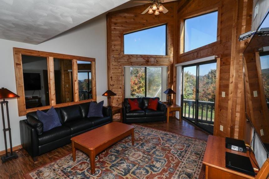 Seven Springs Stoneridge 3 Bedroom & Loft Standard Condo, walking distance to slopes! condo في Champion: غرفة معيشة مع أثاث جلد أسود ونوافذ
