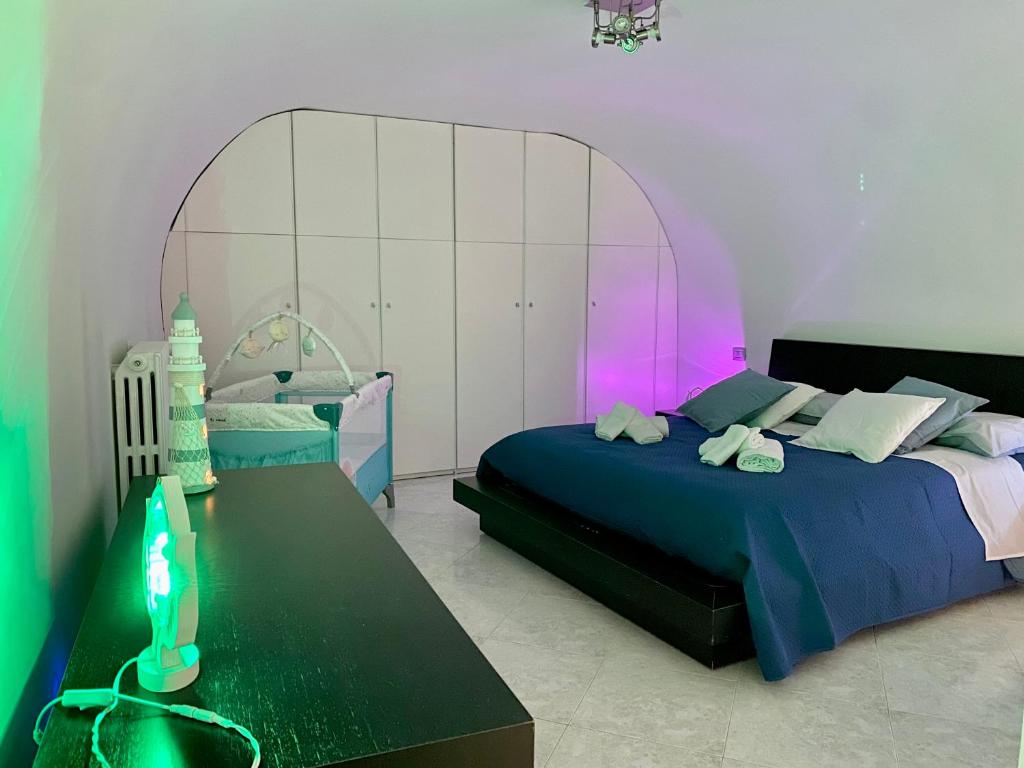 a bedroom with a bed and a table with a neon light at Dimora nel Palazzo Ducale in Giovinazzo