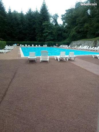 un groupe de chaises assises à côté d'une piscine dans l'établissement Mobile-home, à Saint-Chéron