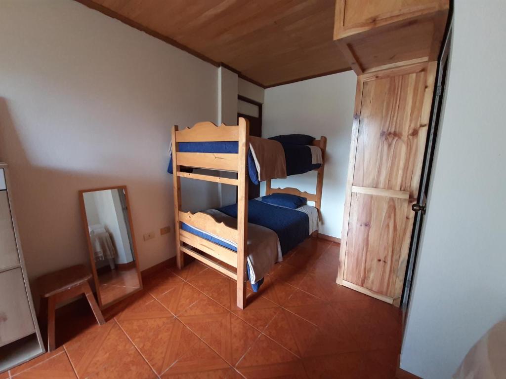 a room with two bunk beds and a mirror at Casa Familia Rubio in Oxapampa