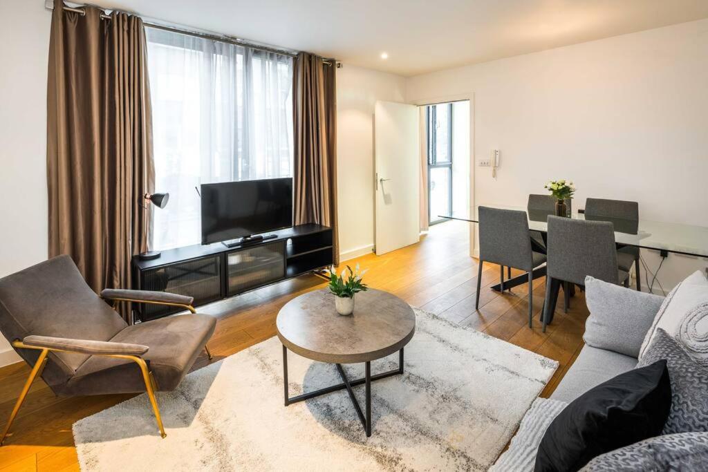 ein Wohnzimmer mit einem Sofa und einem Tisch in der Unterkunft Superb Retreat Flat Central in London