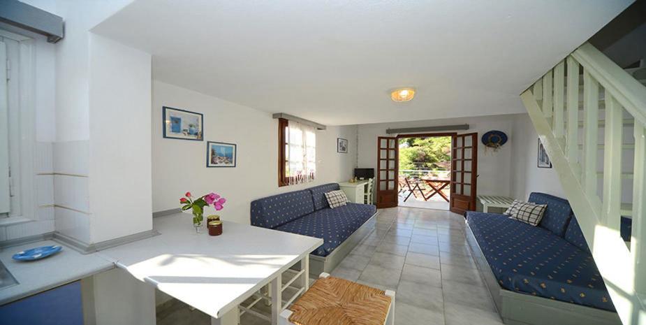 a living room with blue chairs and a white table at Machi Studios in Neo Klima