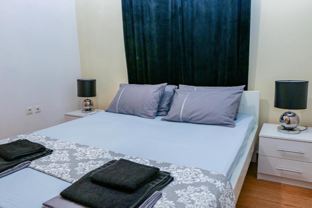 sypialnia z białym łóżkiem z zieloną zasłoną w obiekcie Lana's Rooms w mieście Rodos
