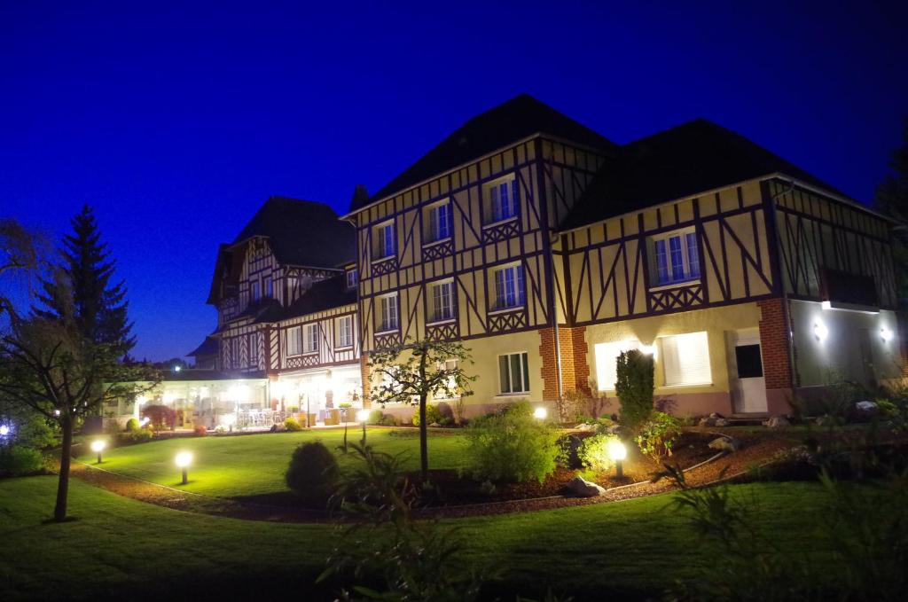 a large building with a yard at night at Logis La Villa des Houx in Aumale