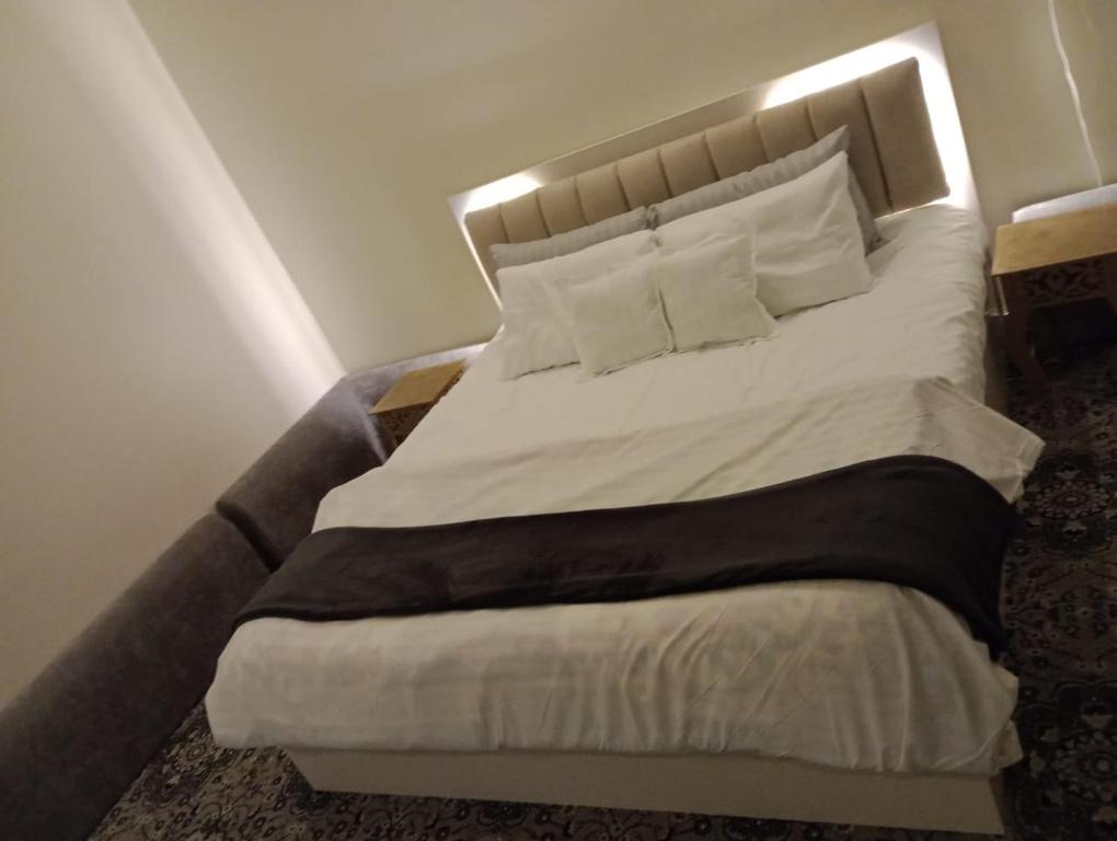 a bedroom with a large bed with white sheets and pillows at 3 Bedroom Apartment in Mecca
