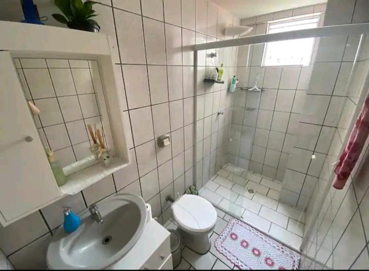 ein Bad mit einer Dusche, einem Waschbecken und einem WC in der Unterkunft Quarto em apartamento da Sandra in Balneário Camboriú