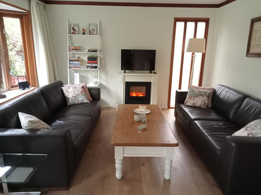 a living room with a couch and a coffee table at Roodborstje 4 persoonschalet Putten in Putten