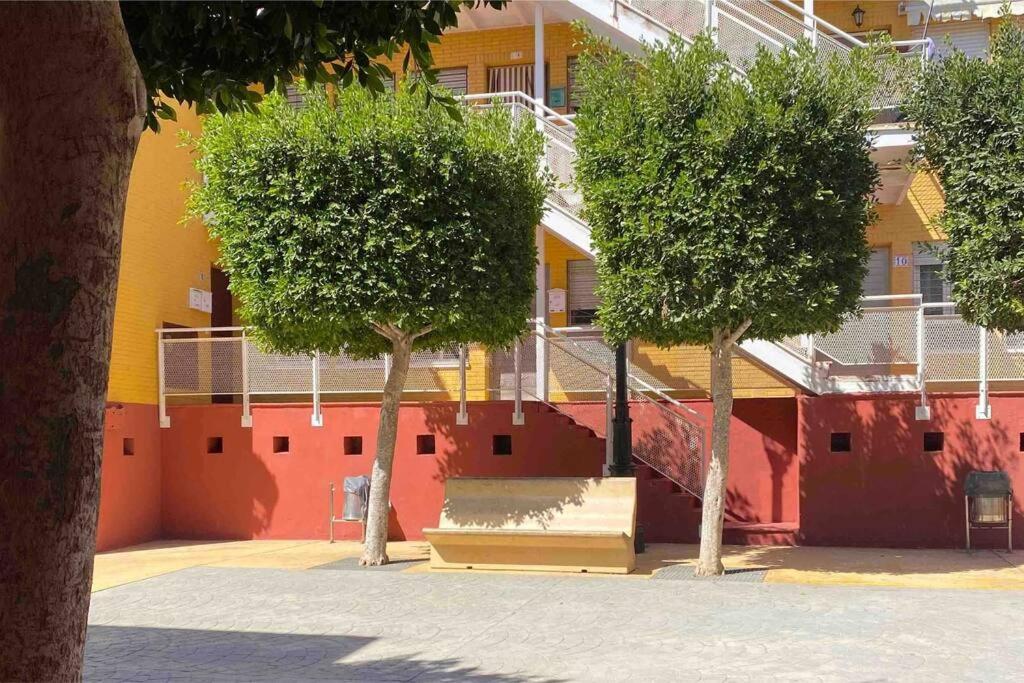 two trees in front of a building with a staircase at Precioso apartamento en Benahadux a 9 km Almería in Benahadux