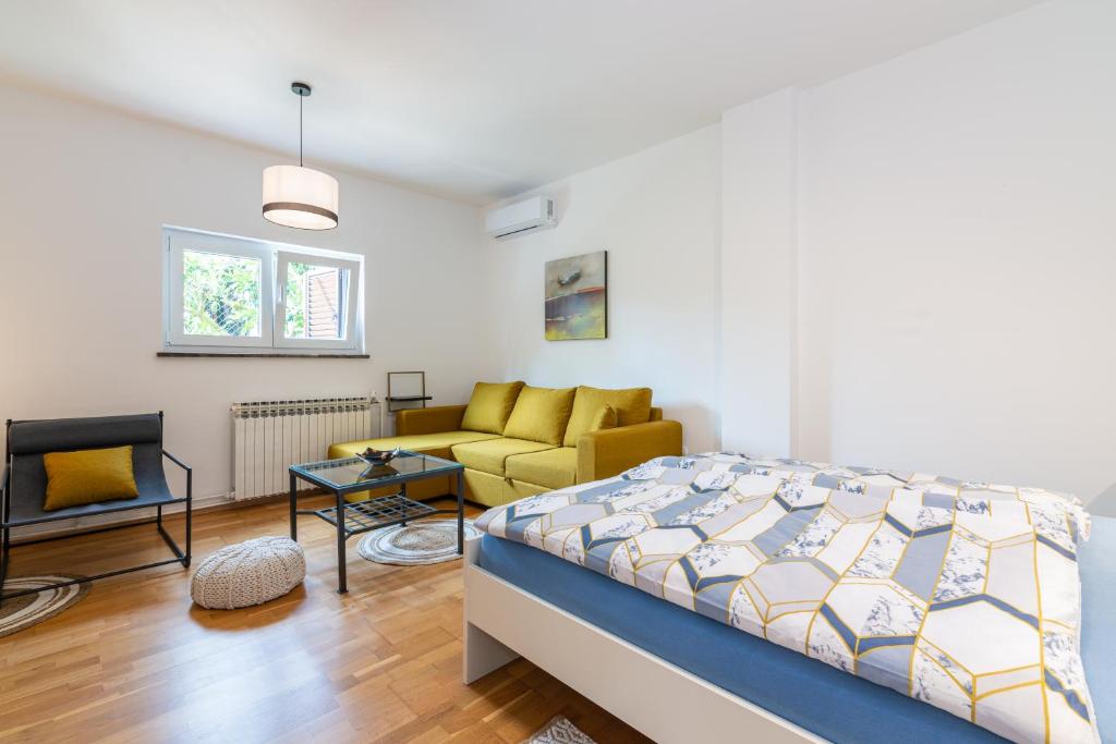 a bedroom with a bed and a couch at Apartment Giardino, Ika-Opatija in Opric
