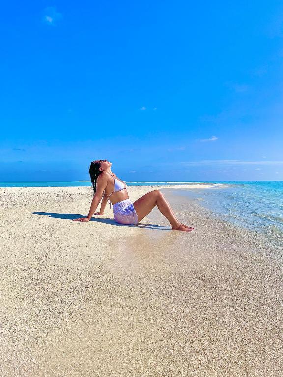 Una donna in bikini sdraiata su una spiaggia di Konut by Thakuru a Guraidhoo