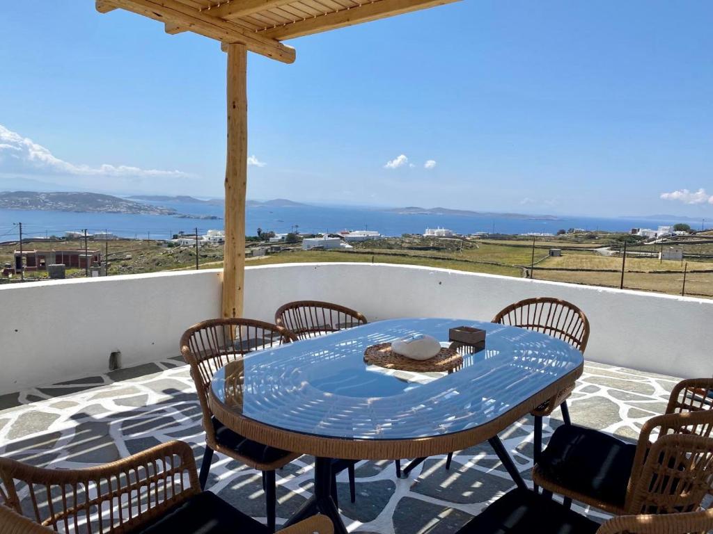 a table and chairs on a patio with a view of the ocean at Lux Mykonos house in Agios Stefanos