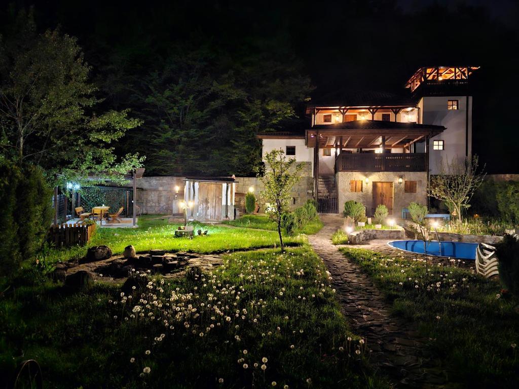 a house with a yard at night with a pool at Casa cu Turn in Sărata-Monteoru