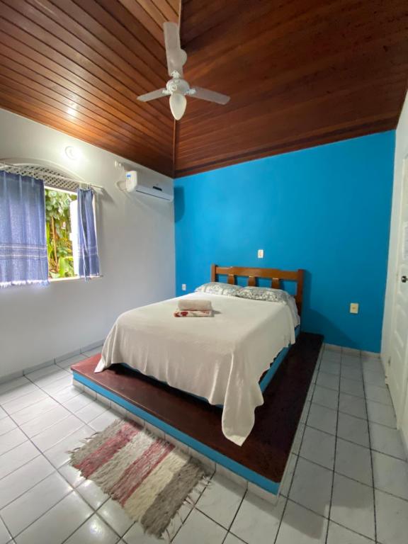 1 dormitorio con 1 cama con pared azul en Pousada Nativo, en Morro de São Paulo