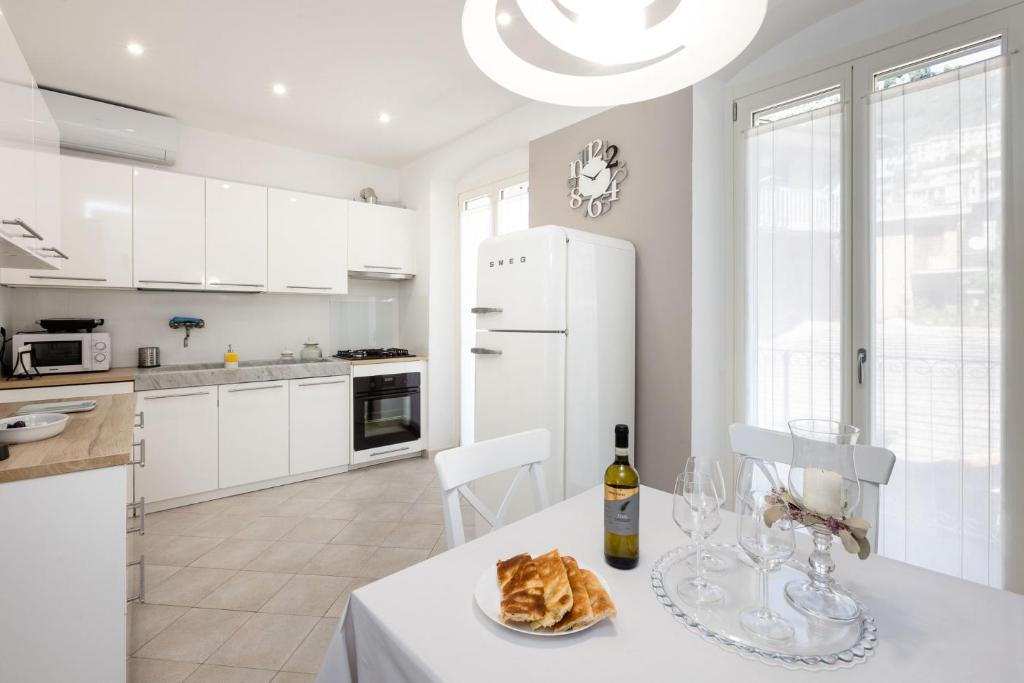 a white kitchen with a table with a bottle of wine at Casa mia a Nervi in Genoa