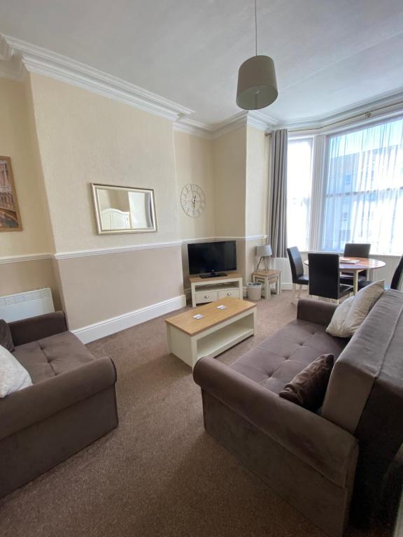 a living room with a couch and a tv at Cedar House, formerly Shamrock House in Llandudno