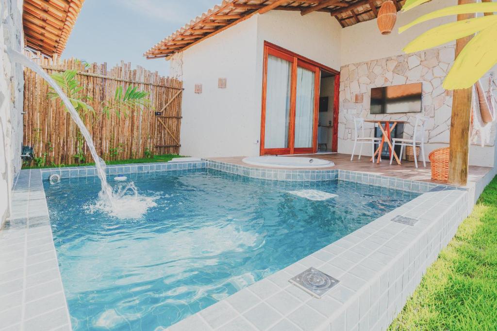 a swimming pool with a fountain in a yard at Pousada Vilagoa in Coqueiro Sêco