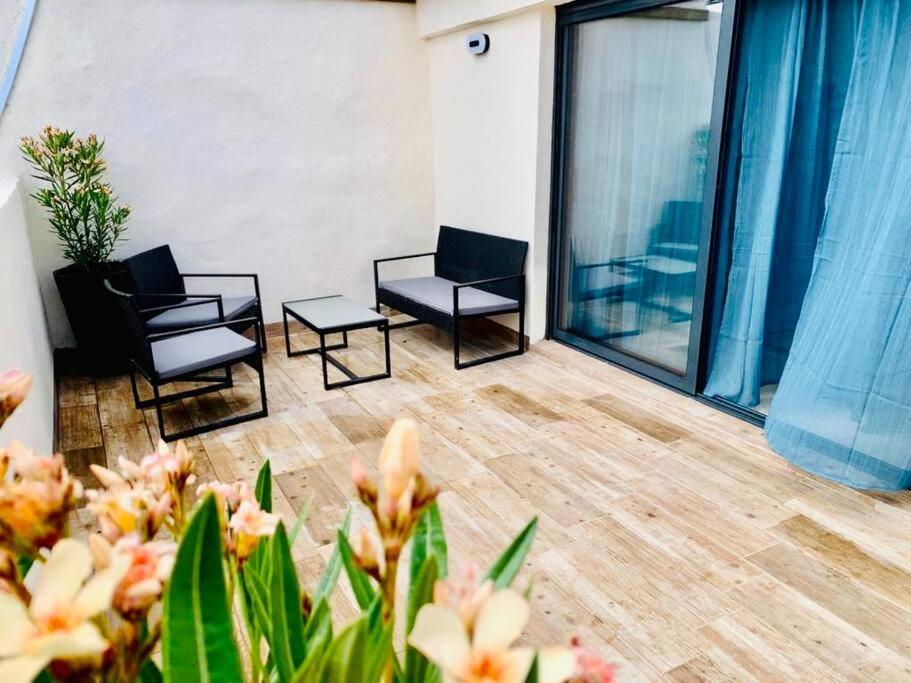 een kamer met 2 stoelen en een balkon met ramen bij Rooftop Agde in Agde