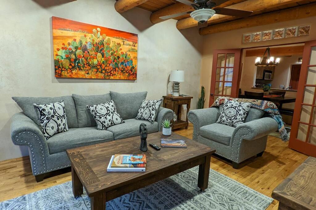 uma sala de estar com um sofá e uma mesa em Magical Santa Fe Stay, Minutes From Town Square, Sleeps 4, includes free parking and outdoor hot tub! em Santa Fé