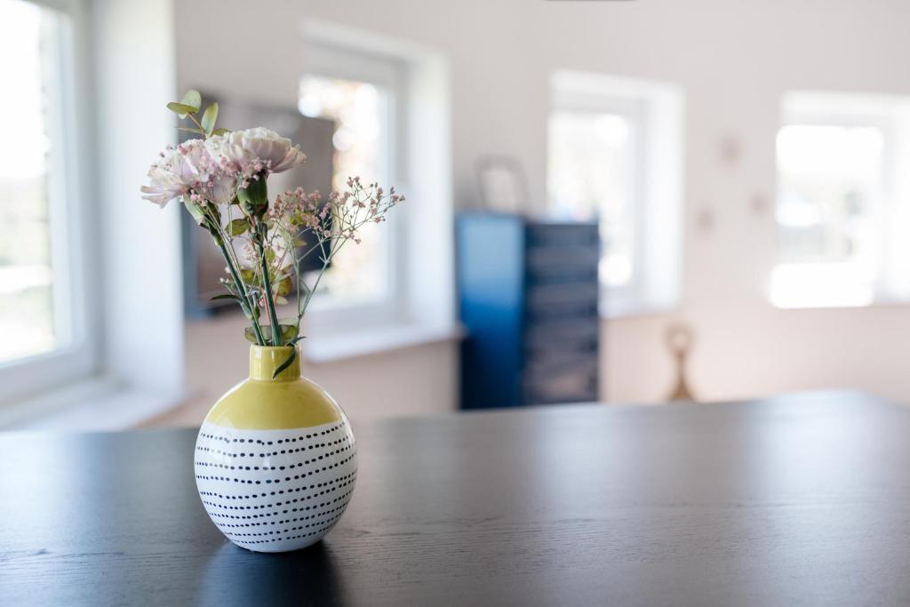 a vase with flowers in it sitting on a table at Meerblick und Salz in der Luft in Fehmarn